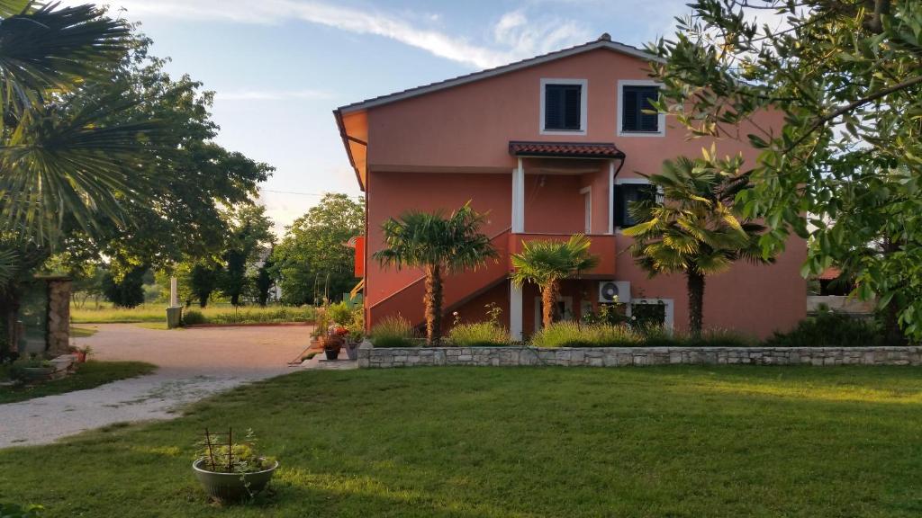 a pink house with a yard in front of it at Apartments Davor in Umag