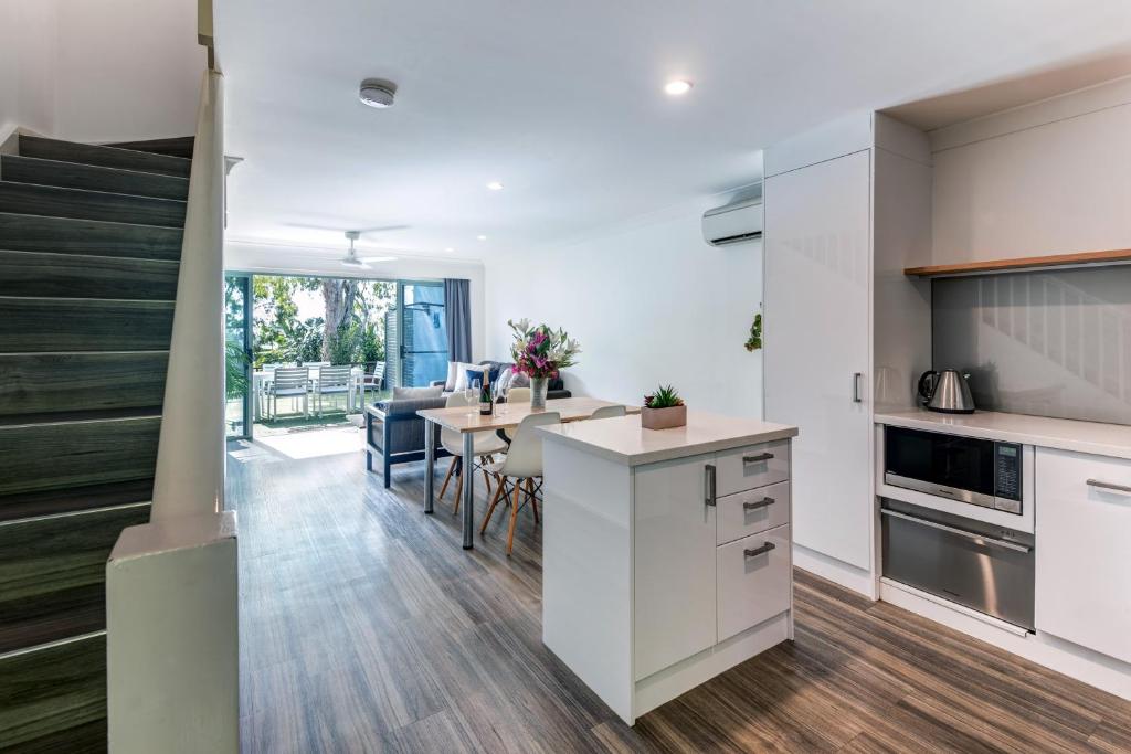een open keuken en eetkamer met witte kasten bij Sunset Water Premium 2 bedroom in Hamilton Island