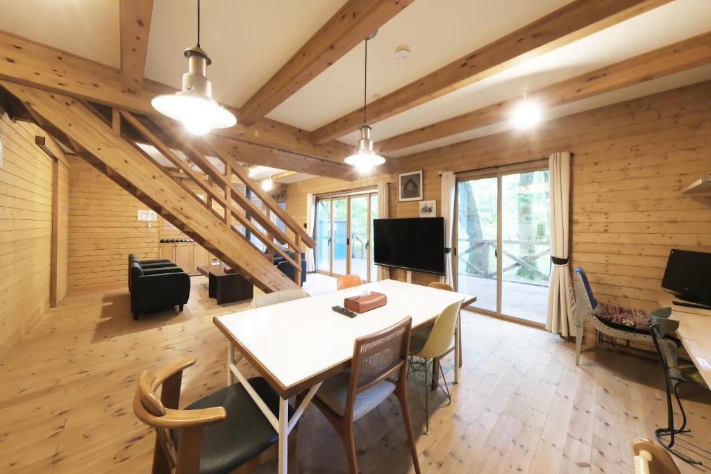 a living room with a table and chairs and a tv at 旧軽井沢 AZ-BASE Karuizawa in Karuizawa