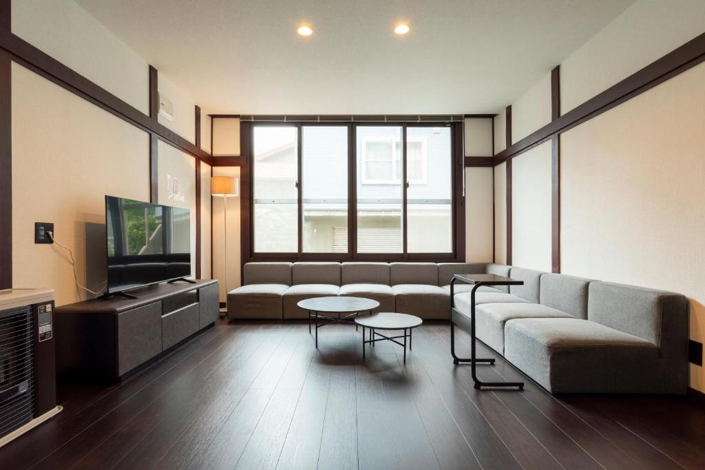 a living room with a couch and a tv at J style villa Sapporo フルリフォーム 長期滞在にもオススメ マーケット近く in Sapporo