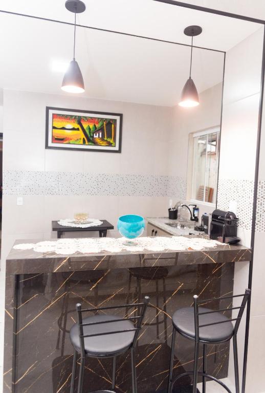 a kitchen with a large stone counter with stools at Casa no centro histórico ,passeio sem carro rock the mountain 2026 in Petrópolis