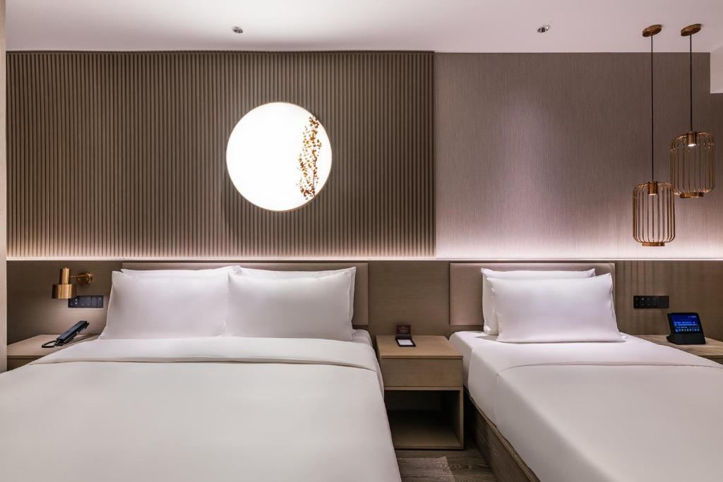 Postel nebo postele na pokoji v ubytování Qingdao Shandong Road Mixc Orange Crystal Hotel