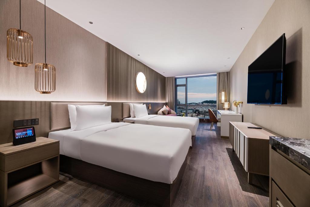 Postel nebo postele na pokoji v ubytování Qingdao Shandong Road Mixc Orange Crystal Hotel