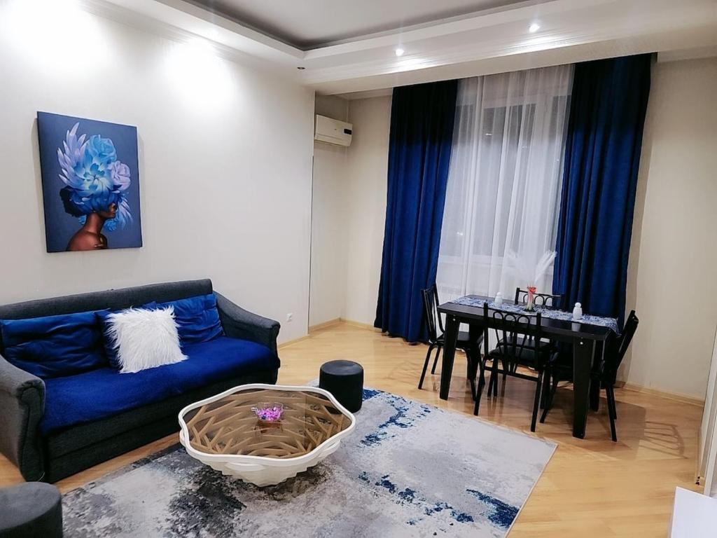 a living room with a blue couch and a table at Ocean Heaven in Tbilisi in Itʼkhvisi