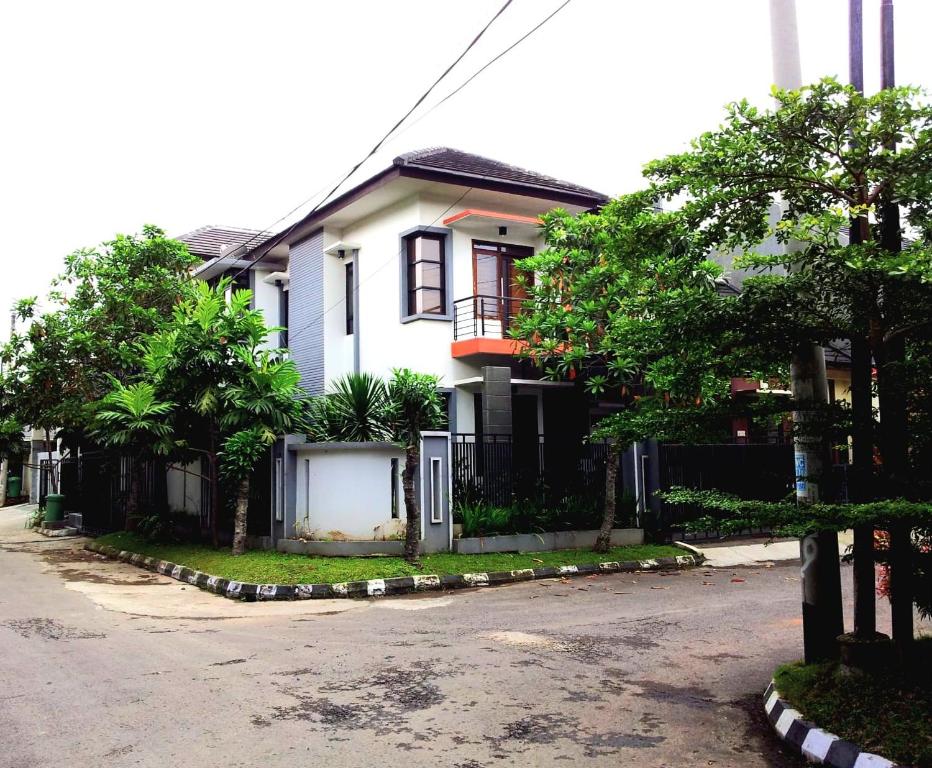 una casa blanca con una valla en una calle en Fatih Homestay, en Bandung