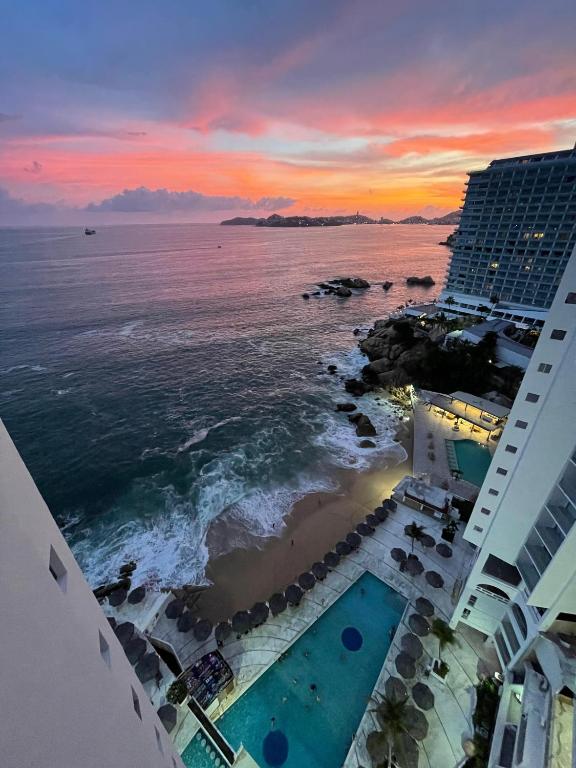 an aerial view of a hotel and the ocean at sunset at SUITE EN TORRES GEMELAS a pie de playa 1403 N in Acapulco