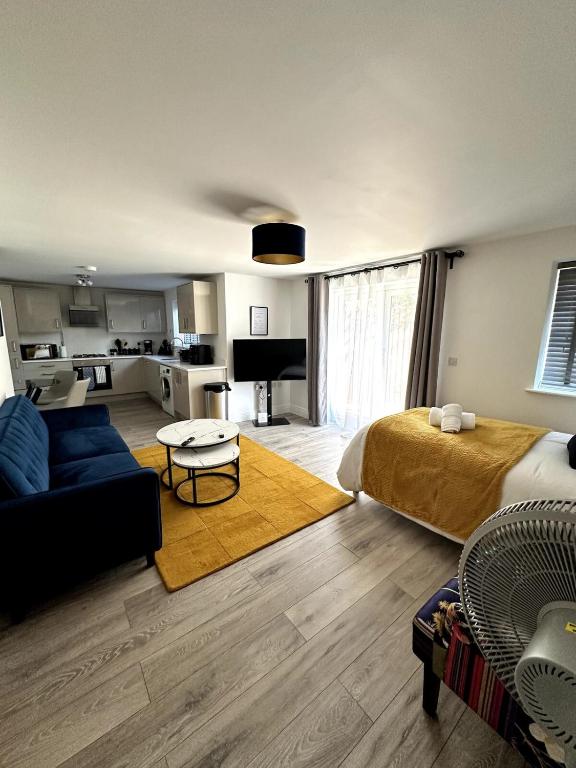 ein Wohnzimmer mit einem Bett und einer Couch und eine Küche in der Unterkunft Modern Ground floor 2 Bed Room Apartment Work Leisure Free Parking in Woking