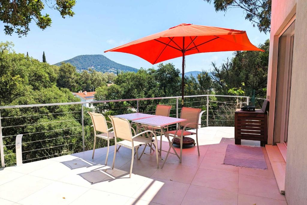 une table et des chaises avec un parasol sur un balcon dans l'établissement Apartment for 3 - near beach, à Carqueiranne