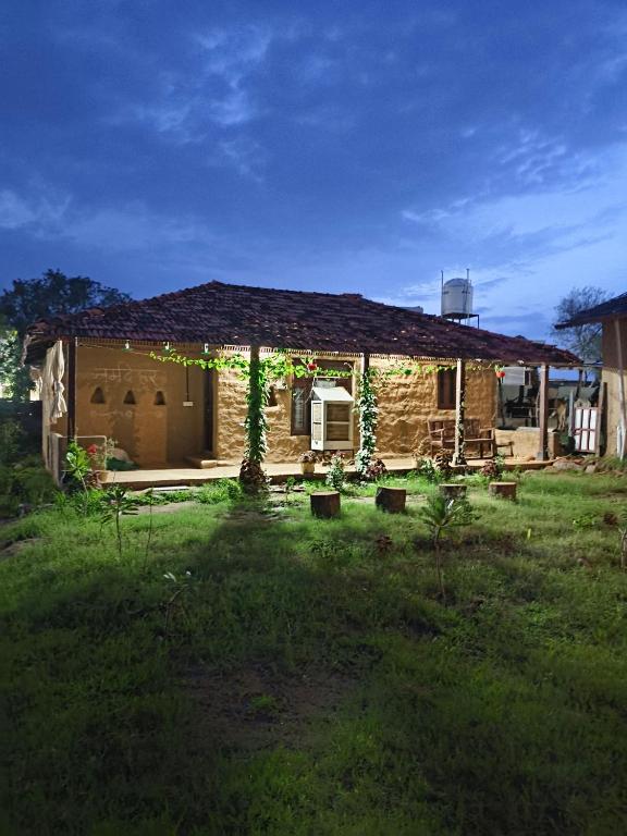 a brick house with a pergola in a yard at Shivakashi Homestay in Maheshwar