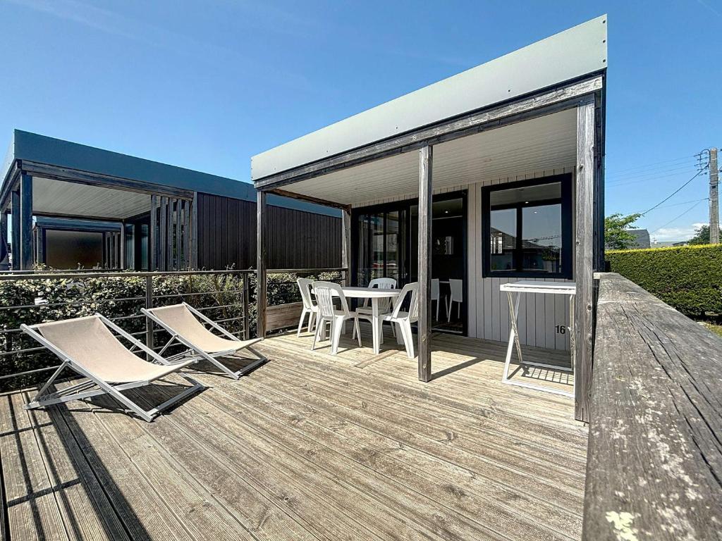 une terrasse avec des chaises et des tables dans un bâtiment dans l'établissement Mobil-Home Confort 4 Pers, à 200m Plage, Terrasse, Piscine Chauffée, Parking, Wi-Fi Gratuit - FR-1-361A-83, à Jullouville