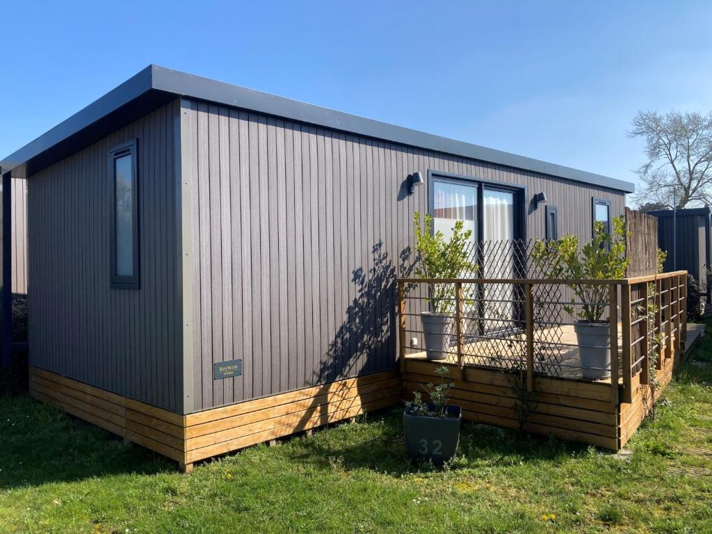 un bâtiment avec une terrasse avec des plantes dessus dans l'établissement Mobil-home 3 chambres avec piscine chauffée, proche plage et commerces - FR-1-361A-16, à Jullouville