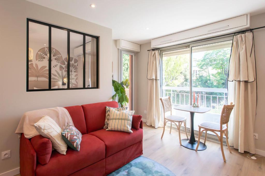 un salon avec un canapé rouge et une table dans l'établissement Appartement cosy lumineux avec balcon, à Nice