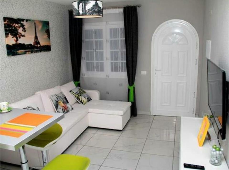 ein Wohnzimmer mit einem weißen Sofa und einem Tisch in der Unterkunft Albatros in Los Cristianos