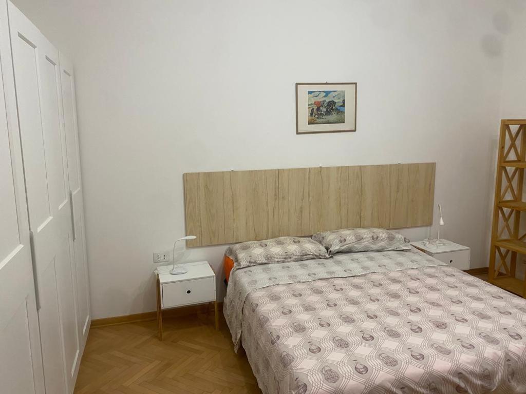 ein Schlafzimmer mit einem Bett und einem hölzernen Kopfteil in der Unterkunft Viale 76 in Triest