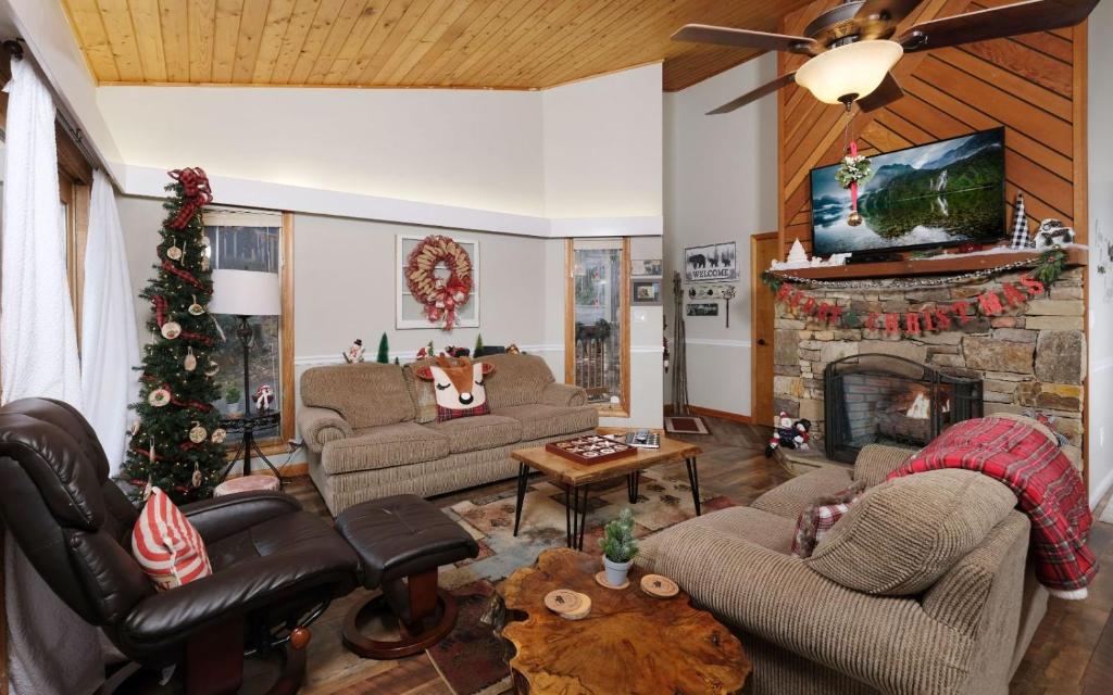 a living room with a christmas tree and a fireplace at Majestic Getaway 1427 in Gatlinburg