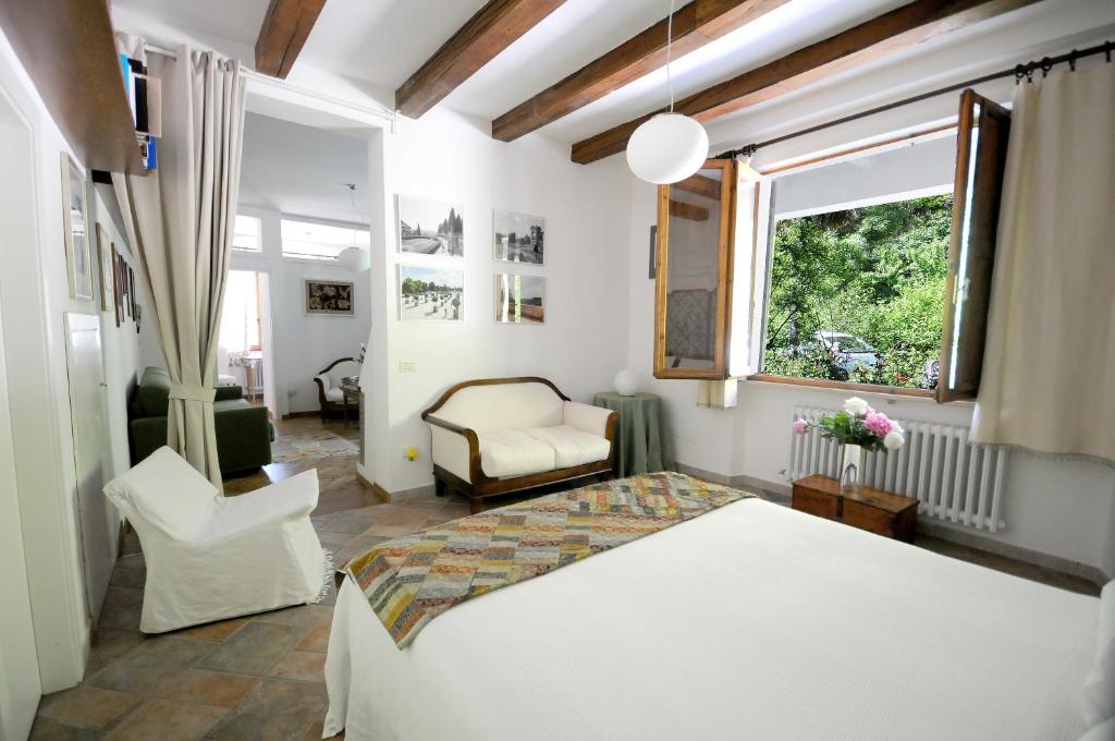 ein Schlafzimmer mit einem Bett, einem Stuhl und einem Fenster in der Unterkunft Casa Disma Urbino in Urbino