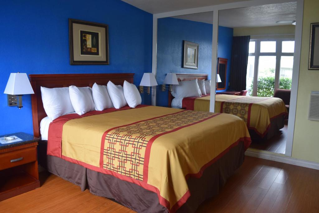 een hotelkamer met 2 bedden en blauwe muren bij Encore Motel in Los Angeles