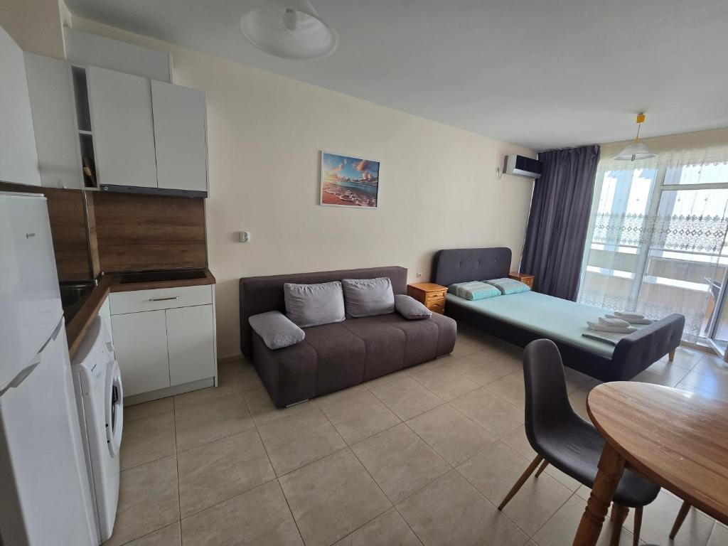 a living room with a couch and a table at Студиa Блу минута от плажа in Pomorie