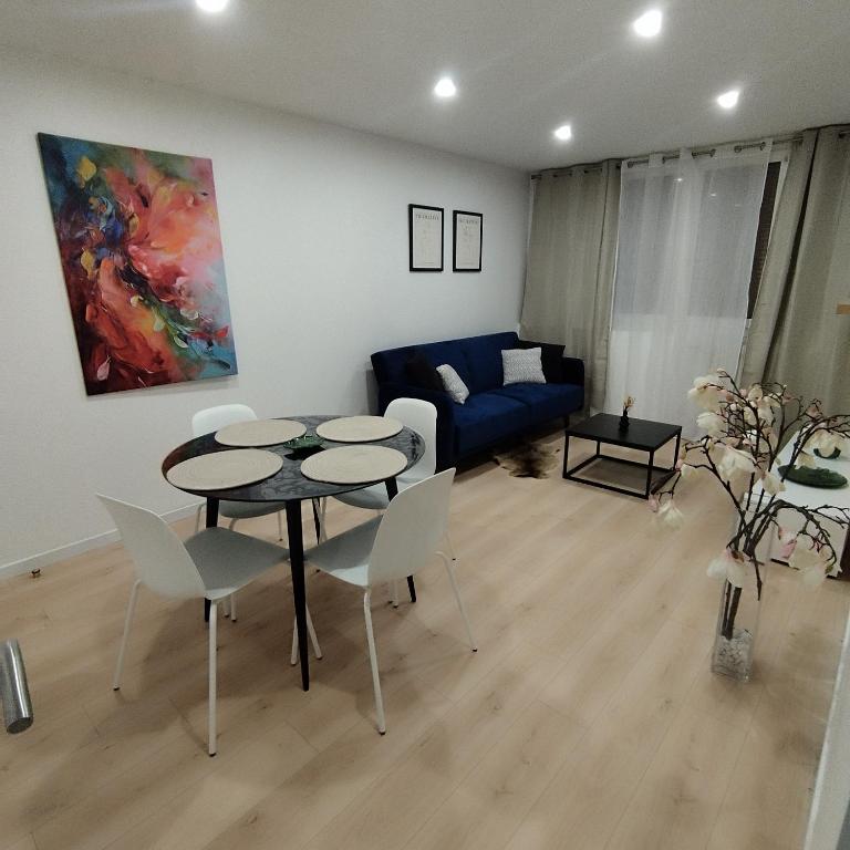 un soggiorno con tavolo, sedie e divano di Superbe Appartement ! a Saint-Étienne