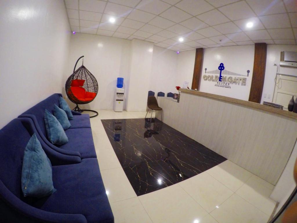 a waiting room with blue couches and a counter at Golden Gate Suites in Dumaguete