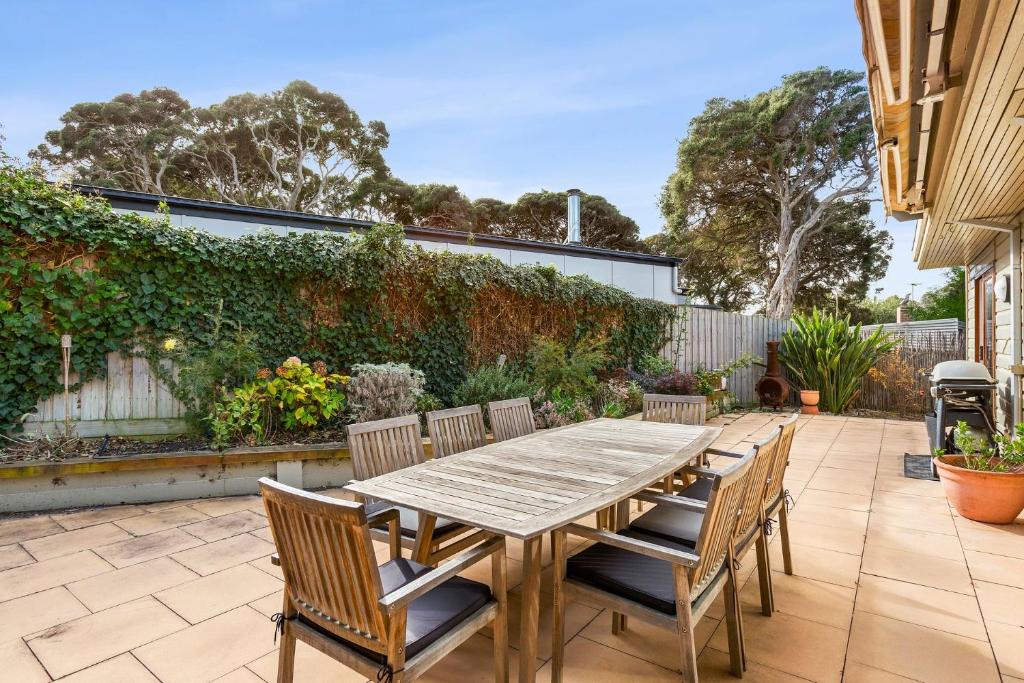 Una mesa y sillas de madera en un patio. en Lockington Breeze, en Point Lonsdale