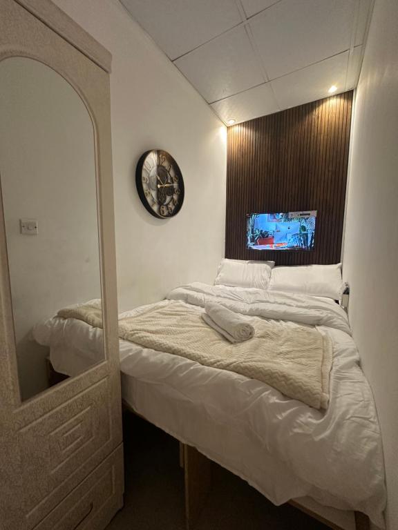 迪拜Lotel Al Barsha 1 at the Mall的一间卧室配有一张带镜子和时钟的床