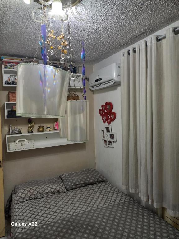 a room with a bed and a chandelier at apartamento cop30 in Ananindeua