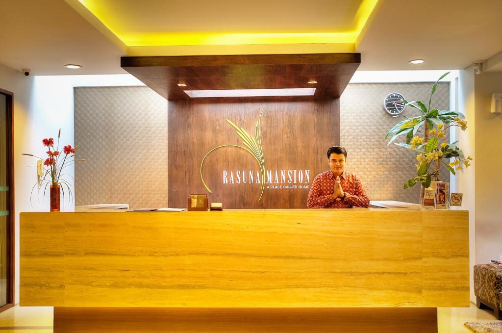 un hombre sentado en una recepción en un vestíbulo en Rasuna Mansion, en Yakarta