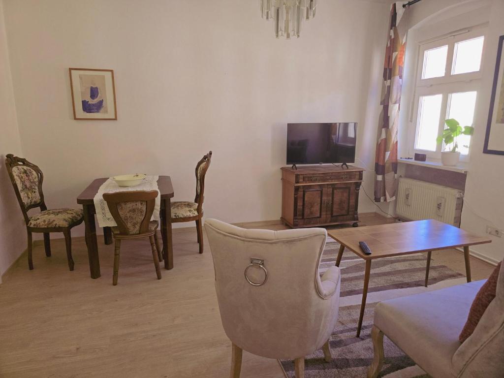 a living room with a tv and a table and chairs at Haus Marienblick in Beeskow