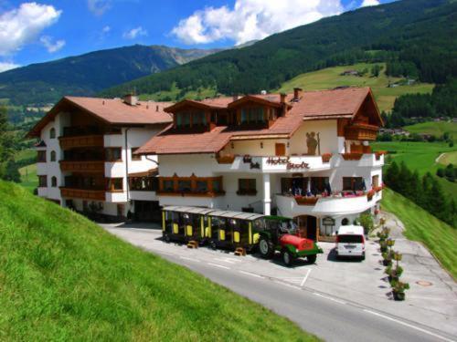 ein großes Gebäude mit einem Bus davor in der Unterkunft Hotel Stolz in Matrei am Brenner