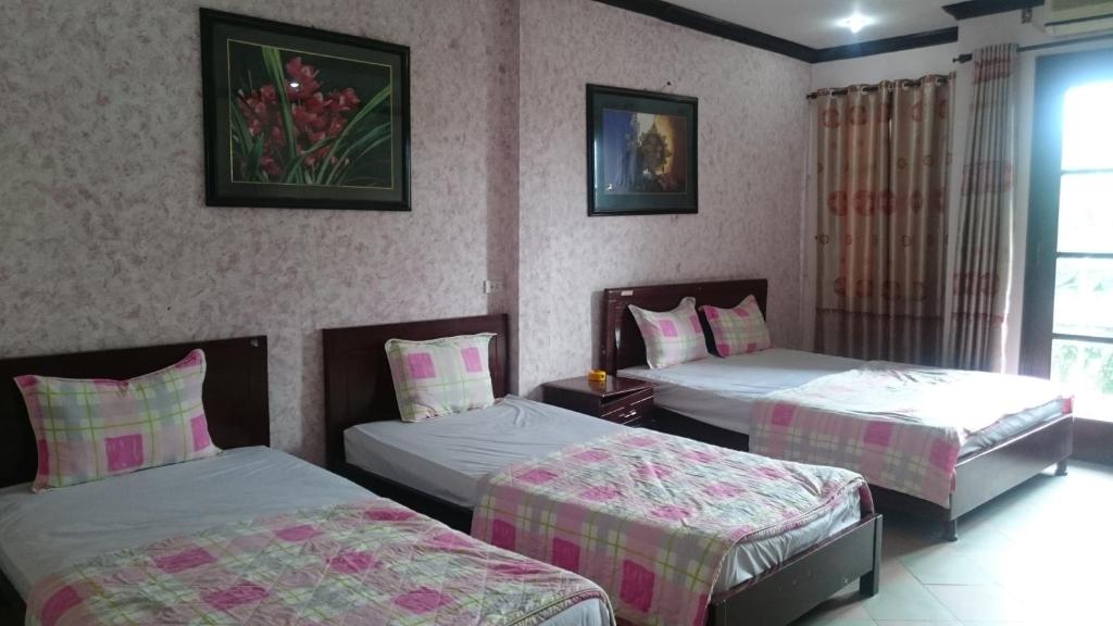 a hotel room with two beds and a window at Hai Duong Guesthouse in Hòa Bình