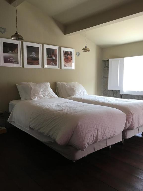 una camera con due letti con lenzuola bianche e una finestra di RC Rooms a Porto