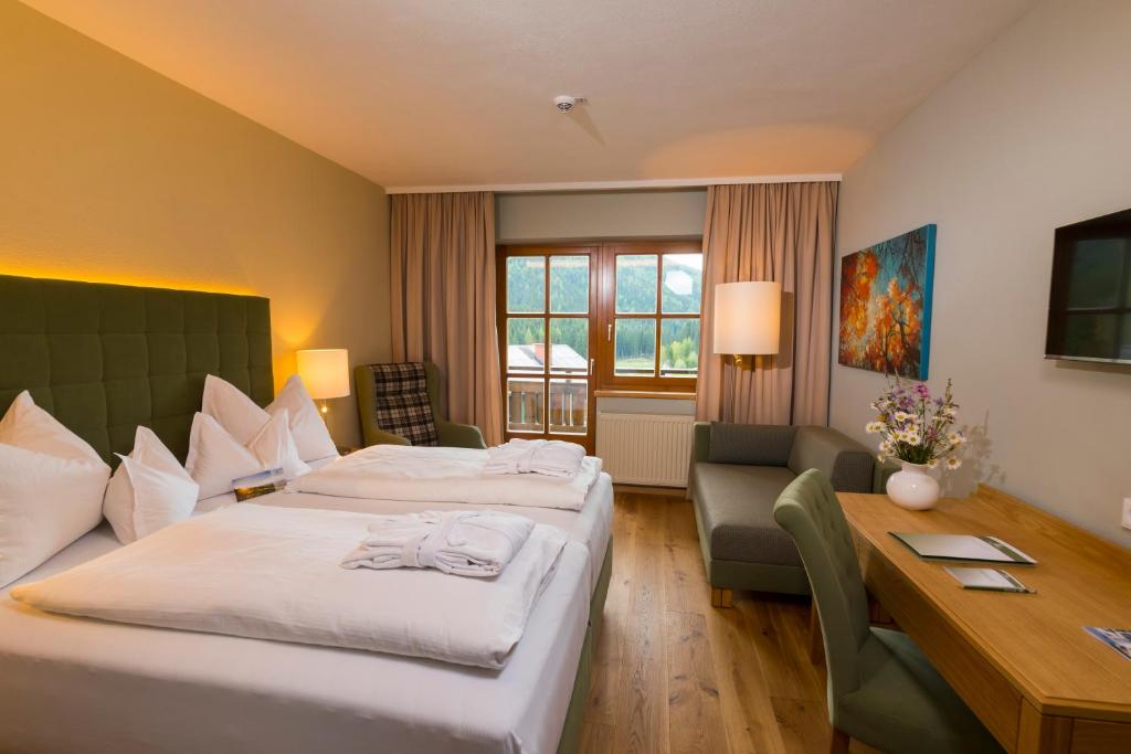 una camera d'albergo con due letti e una scrivania di Hotel Teichwirt a Fladnitz an der Teichalm