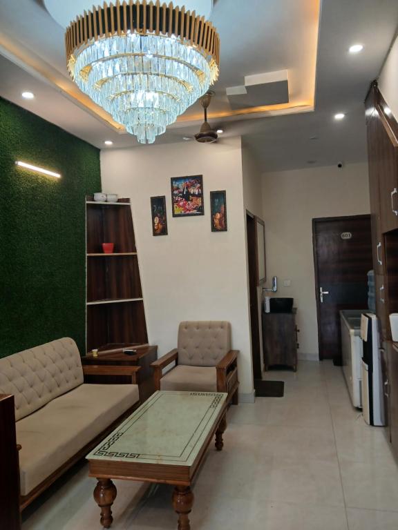 齐拉克普尔Hotel Golden Rooftop的带沙发和枝形吊灯的客厅