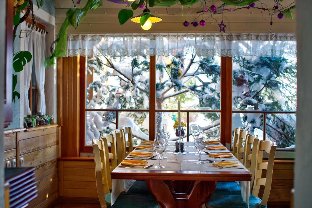 a dining room with a table and a large window at Apartmaji Smogavc in Zreče