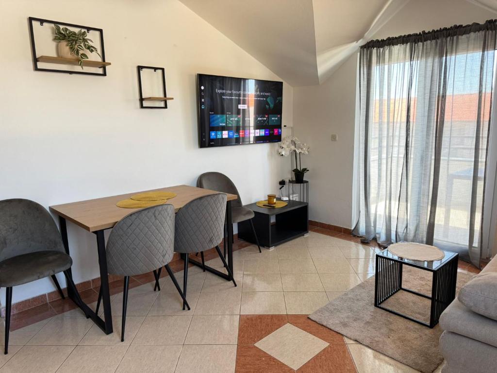 a living room with a table and chairs and a couch at Apartment Luxury B Vodice in Vodice