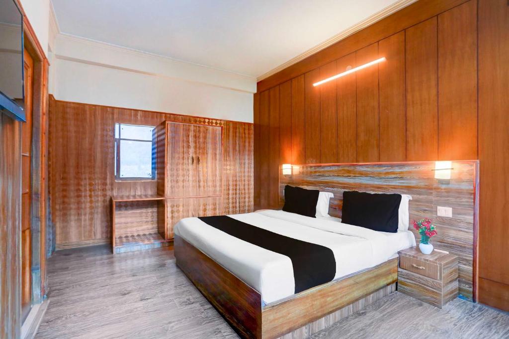 Un dormitorio con una cama grande con paredes de madera. en Hotel O Manali Near Hadimba Temple, en Manali