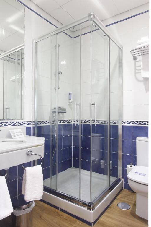 a glass shower in a bathroom with a toilet at Rincón de Gran Vía in Madrid