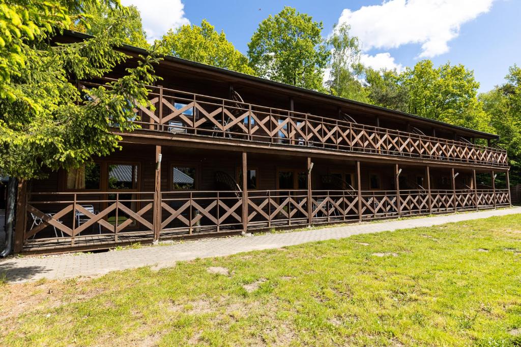 a large wooden building with a fence around it at Ośrodek Rehabilitacyjno Wypoczynkowy Bursztyn in Jantar