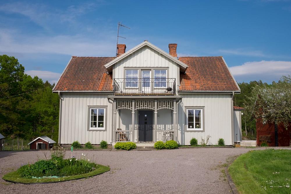VimmerbyにあるRåshults Gårdのバルコニー付きのホワイトハウスです。