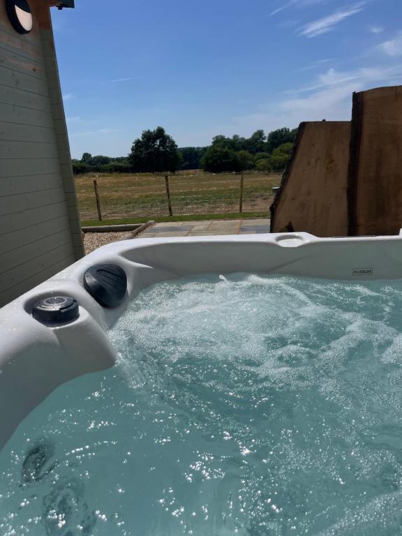a bath tub filled with water in a yard at Apple Blues Farm in Ashford