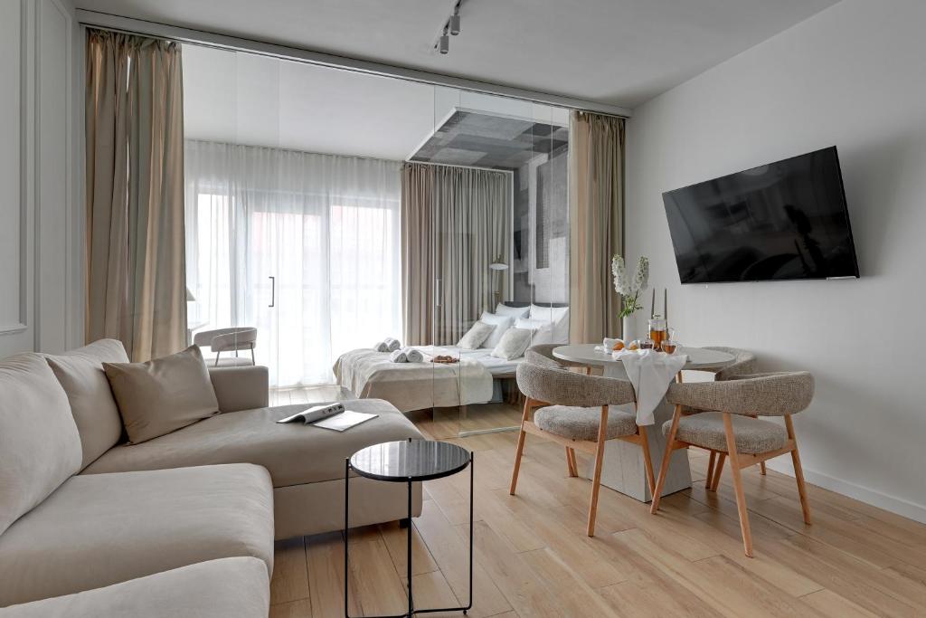 ein Wohnzimmer mit einer Couch und einem Tisch in der Unterkunft Waterlane Riverside - SPA, Pool, Gym &amp; Parking by Downtown Apartments in Danzig