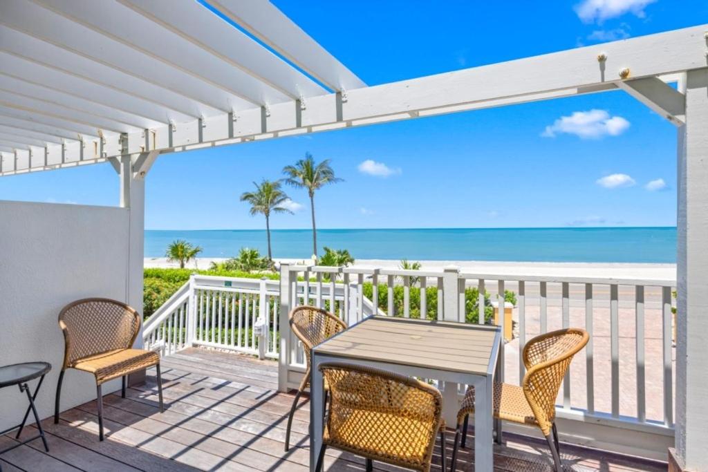 une terrasse avec une table et des chaises et la plage dans l'établissement Ark condo, à Captiva