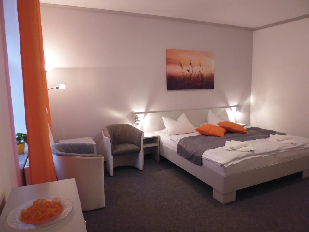 a hotel room with a bed and a chair at Pension Kamenný Dvůr in Mariánské Lázně