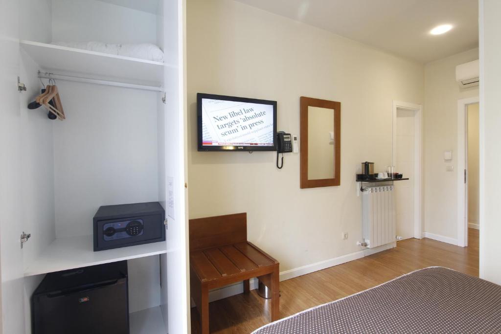 a room with a bed and a tv on a wall at Rincón de Gran Vía in Madrid