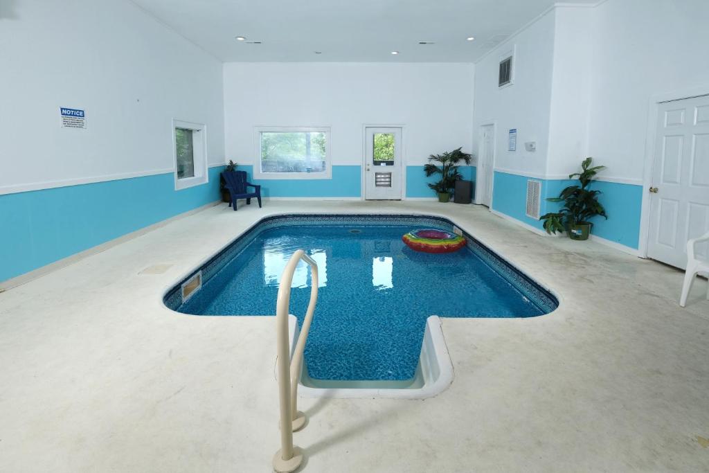 a large swimming pool in a room with blue walls at Edge of Paradise in Pigeon Forge