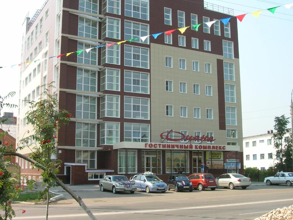 a tall building with cars parked in front of it at Hotel Diana in Arzamas