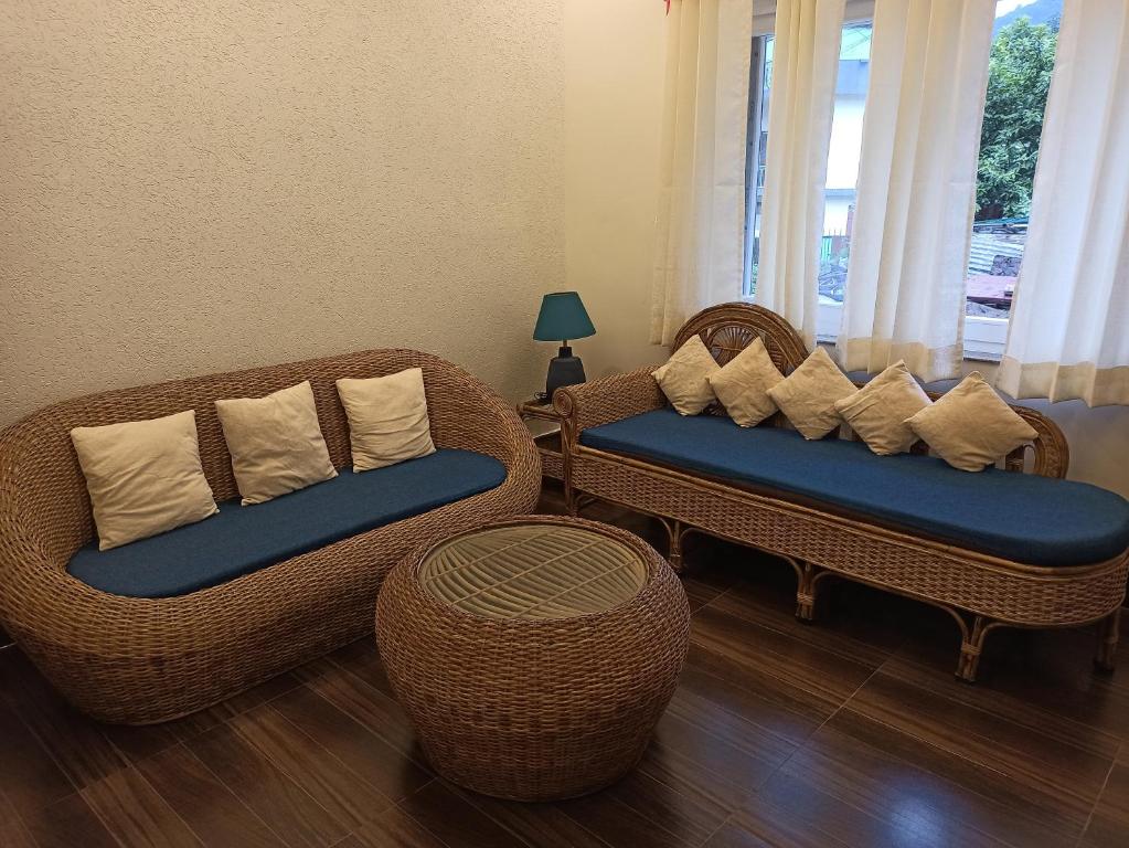 two wicker chairs and a table in a living room at Gaani Homestay Uttarkashi in Uttarkāshi