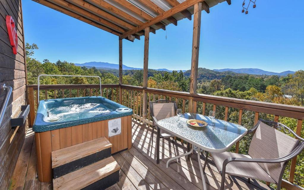 een hot tub op een terras met een tafel en stoelen bij Mountain Romance in Sevierville