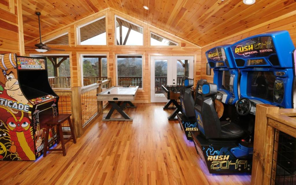 Una gran sala con mesa de billar y juegos de arcade. en Carsons Place, en Gatlinburg